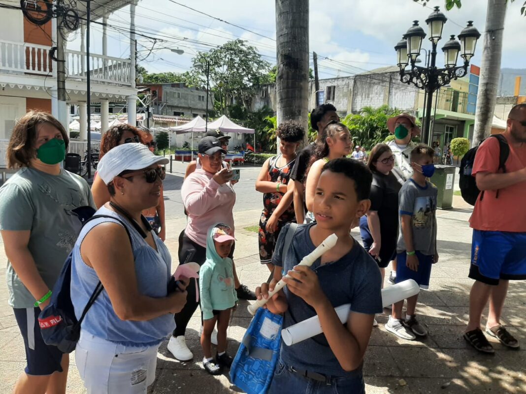 Turistas de crucero en Puerto Plata encuentran una oferta inesperada: Leyendo por un tubo